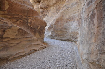 Beautiful rocks and canyons in the wild nature and the dry desert of Wadi Ghweir in Jordan on a bright sunny day
