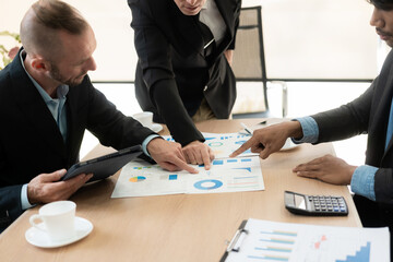 Diverse teams of top managers discuss, brainstorm, use digital tablets. Business partners discuss financial reports. Planning investment strategy in real estate