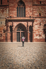 Vertical shot of a tourist shooting the Basel Minster Cathedral in Basel, Switzerland