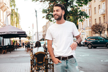 Portrait of handsome smiling stylish hipster model. Man dressed in white T-shirt. Fashion male...