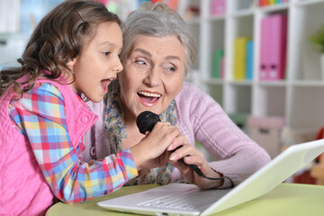 senior woman with granddaughter singing karaoke