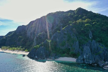Fototapeta na wymiar Panorama drone shot of the paradisiacal beach of Coron, Palawan in the Philippines with fine white beach, palm trees and majestic rocks.