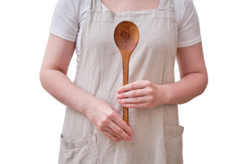 A large wooden spoon in the hands of a woman in the kitchen, isolated on a white background. Women's hands hold a salad spoon