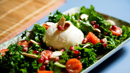 Delicious and healthy kale salad, mozzarella cheese and cherry tomatoes.