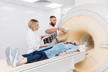 Woman doctor radiologist explains good results of CT scanning for young female patient, showing the...