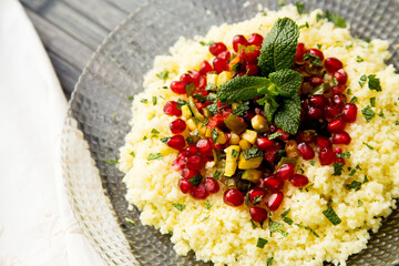 Couscous salad with pomegranate and mint leaves.