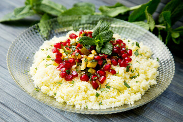 Couscous salad with pomegranate and mint leaves.