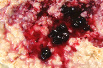Oatmeal with Jam. Creamy Oat Porridge with Blueberry Berry Marmalade is Spinning on Turntable. Superfoods concept. Selective Focus. Copy Space for Your Text. Healthy Breakfast Table. Top View