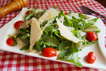 Delicious salad fresh ingredients, tomatoes and arugula.