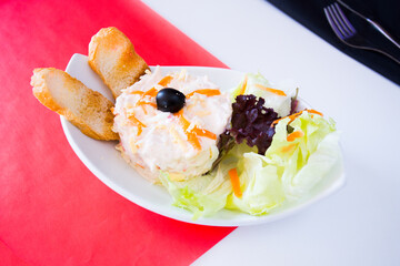 The traditional Russian salad or Olivier salad is prepared with potatoes, tuna, carrots and peas.