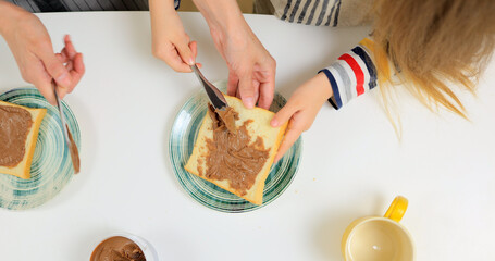 Mom and daughter making breakfast out of peanut butter sandwiches