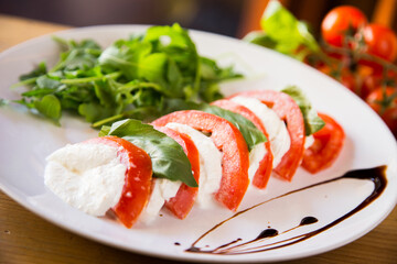 Caprese salad is an Italian salad made up of sliced tomatoes and fresh mozzarella, and fresh basil leaves.