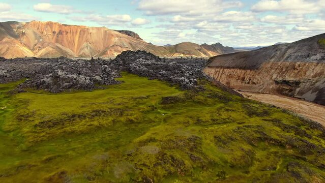 aerial view drone flying over lush green mountain revealing volcanic landscape,landmannalaugar iceland,sunny day summer time