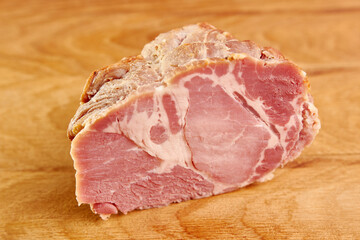 Ham meat cut into slices on a wooden board.