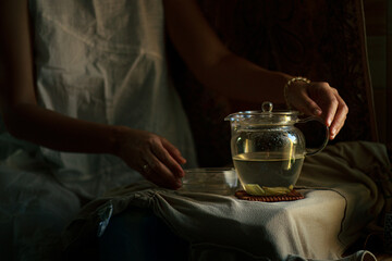 Woman preparing a pot of ginger infusion as part of a healthy morning routine, showing slow living, wellness and holistic healing