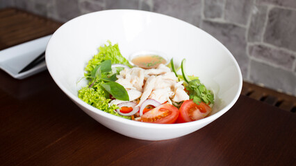 Delicious Asian salad with boiled chicken, tomatoes and lettuce