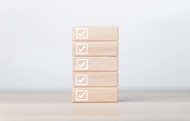 wooden block showing check mark Checklist ideas in business surveys and questionnaires copy space