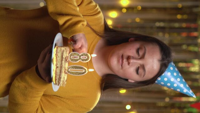 Beautiful happy young woman wearing sweater holding birthday cake number 80 golden candles burning by lighter. Concept of celebrating birthday and anniversary. POV.