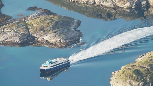 Ferry Boat Leaving Wake In The Calm Water Of Fjord In Lovund, Norway. - static