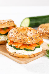 Bagel sandwich with salmon and cream cheese for breakfast on a kitchen board portrait format