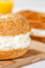 Bagel sandwich with cream cheese for breakfast close up portrait format