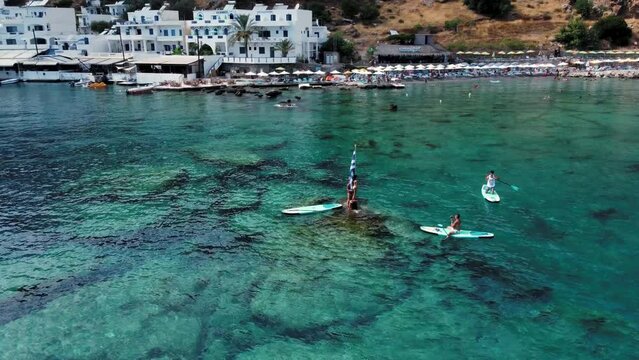 People Having Fun And Taking Pictures In Idyllic Destination In Crete, Greece. Drone shot Orbit.