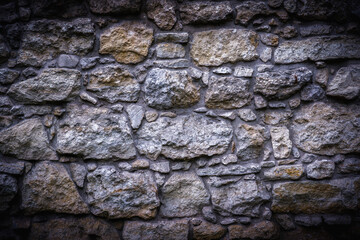 Fragment of an medieval ancient stone wall texture background.
