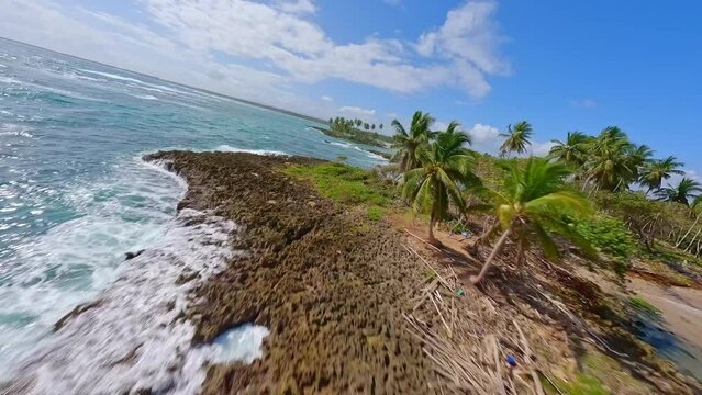 Fpv flight over tropical islands with palm trees and clear Caribbean Sea during summer - Playa Los Coquitos, Dominican republic