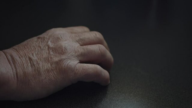 Old Hand Calmly Drumming Fingers On A Dark Table Close Up 4K