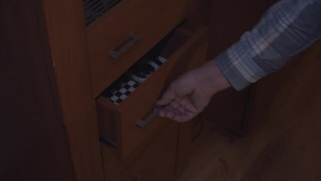 Grabbing a flashlight from a drawer with chess at night 4K