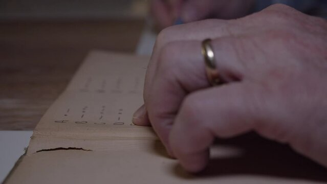 Man reading morse code from an old book, golden ring on tiger close up 4K