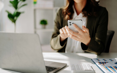 Confident businesswoman working on laptop,tablet and tablet at her workplace at office..