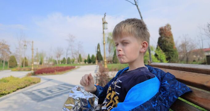 Boy enjoying eating potato chips in the park
