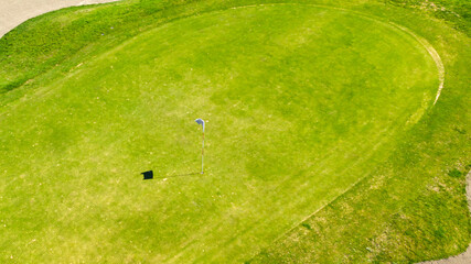 Closeup of the final hole of a golf course. Aerial view of a golf club. The sports club is empty and nobody is playing. Sports concept.