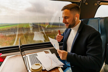 Businessman commuting by train, talking for a video call via laptop,discusses project results and data research