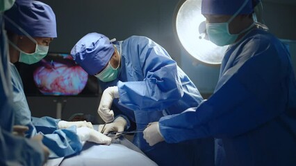 Team professional surgeons and nurses in uniform at work in operating room,performing heart transplant surgery operation under bright lamps and looking at screen.Teamwork surgeon in operating room - Powered by Adobe