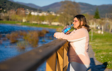 beautiful woman drinking water on foot of a river copy space promotional content