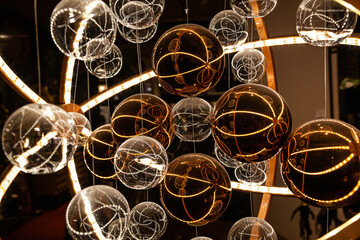 Glass translucent spheres on pendants in white and brown colors in a futuristic style close-up.