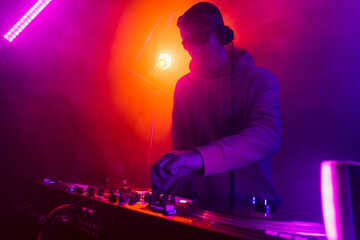 Fototapeta na wymiar Male DJ playing music in the night club