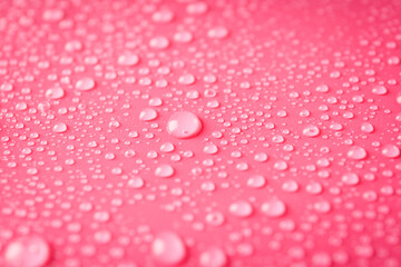 Pink background with water drops, close up