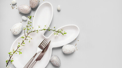 beautiful light easter mockup with bunny plate and cutlery, gold and marble eggs, cherry blossoms and confetti on a white background. top view. copy space. flat lay. place for text