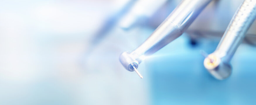 Closeup photo of dental handpieces and equipment on dental chair with blured background.