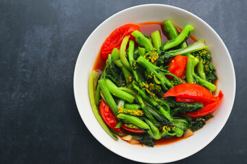 Top view of Stir fried vegetables with soy sauce on black background. 