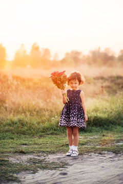 Happy little girl walking in the summer park. portrait of a child. Bouquet of flowers in hands. Children's holidays and recreation. happy child. Mothers Day.