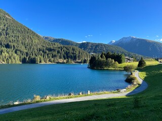 Sports and recreational trail along the alpine lake Davos or loop around mountain Lake Davosersee, Davos Dorf - Canton of Grisons, Switzerland (Kanton Graubünden, Schweiz)