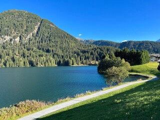 Sports and recreational trail along the alpine lake Davos or loop around mountain Lake Davosersee, Davos Dorf - Canton of Grisons, Switzerland (Kanton Graubünden, Schweiz)