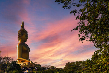 large golden yellow buddha At Wat Muang, which is an important religious tourist destination In Ang Thong Province in Thailand