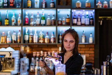 young woman bartender Making Cocktail in bar
