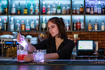 young woman bartender Making Cocktail in bar