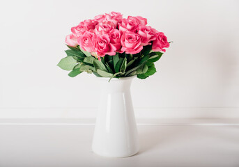 Beautiful bunch of fresh pink roses in full bloom against white background. Bouquet of flowers. Valentine's day or Mother's day card.